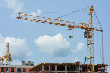 Construction site with a large tower crane at a modern building project. The unfinished building home for themes of architecture, urban development, and real estate growth.