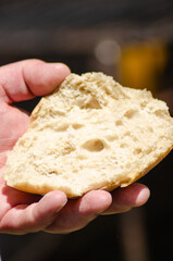 A hand holding a piece of fresh, rustic artisan bread, Artisanal Food