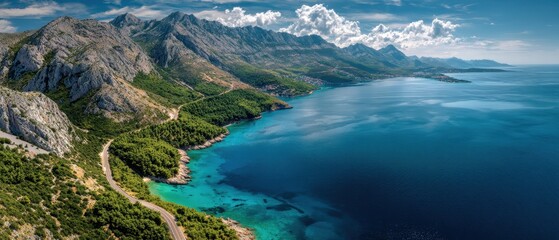 Majestic Mediterranean coastline with dramatic mountains meeting azure waters under a cloudy sky.