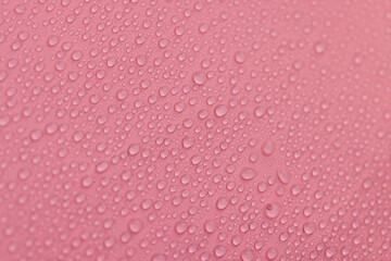 a smooth red surface covered with water droplets, a beautiful wet red film in a large number of water drops