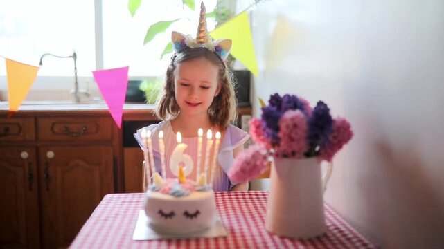 Happy little girl with unicorn hair decoration celebrating her sixth birthday