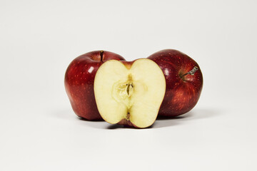 Group of red apples on a table in close-up with copy space under a white background
