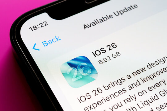 iOS 26 update icon and text on iPhone with pink backdrop, angled close-up showing header. Stafford, United Kingdom, September 15, 2025