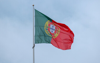 Waving Portugal flag in Lisbon against a cloudy sky, symbol of national pride in Europe