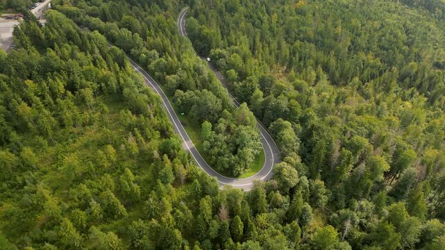 Aerial view of traffic on a tight mountain hairpin. top‑down over the forest. The Salmopol Pass. Beskids, Poland, Szczyrk