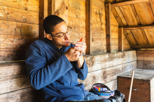 Male Climber preparing cigarette Inside Rustic Hut