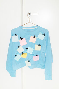 Blue shirt with colourful paper post it notes in it with golden clips