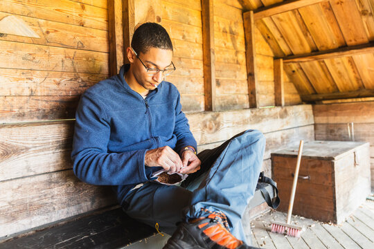 Male Climber preparing cigarette Inside Rustic Hut