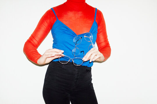 Person holding multiple pairs of glasses in business work office
