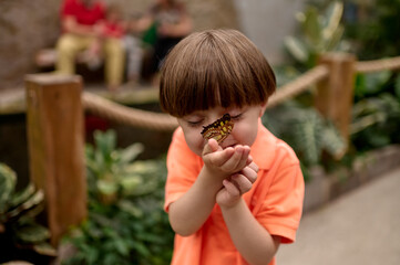 Boy smiling with butterfly on his face


