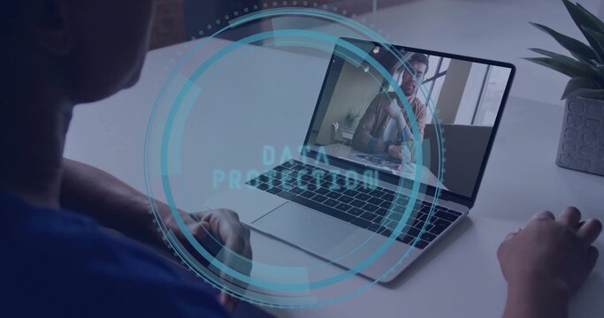 Joining call woman wearing blue shirt using laptop at desk, data protection overlay, copy space - Powered by Adobe