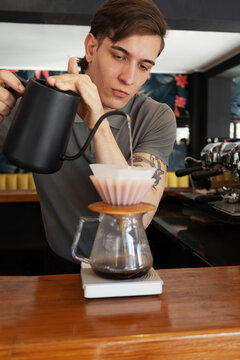Barista pouring hot water into coffee filter for manual brew