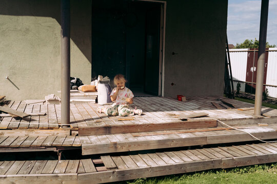 Little girl having a cookie break on a construction porch