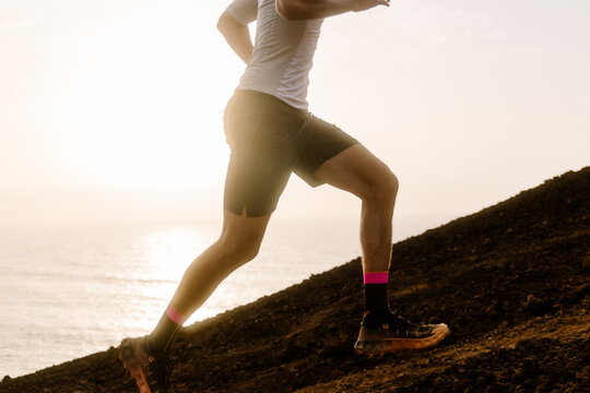 Anonymous high performance athlete speeding up a rocky slope