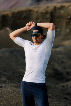 Expert athlete standing boldly with raised arms above his head