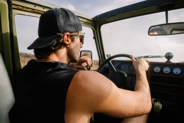 Man in athletic wear driving an off-road vehicle on a rugged trail 
