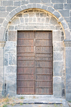 Rustic Arched Wooden Door Set in Ancient Stone Building