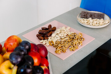 Chopping board with nuts, seeds and dates arranged on a kitchen table
