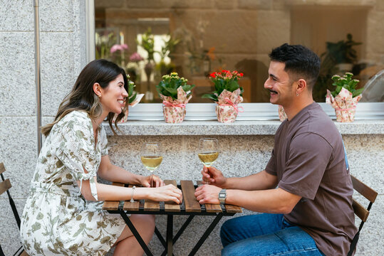Portrait of a modern couple sitting in a terrace and drinking wine 