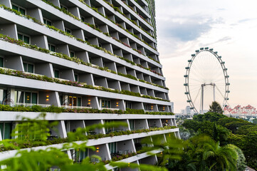 Green architecture with lush balconies and city ferris wheel