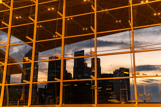 Glass facade reflecting evening cityscape
