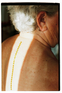 back of a woman with white hair and sparkles on her back