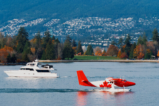 Seaplane and Yacht Crossing Paths on Vancouver Waters
