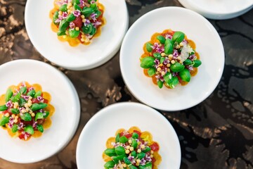 Gourmet appetizers with vibrant toppings on plates.