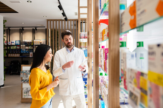 Pharmacist assisting customer with medication choice