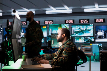 Agent in control center planning, analyzing and gathering information on enemy troops. African...