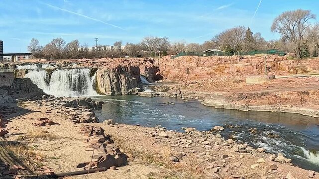 Waterfalls at Sioux Falls, Falls Park, with Red Quartzite Rocks, Blue Sky, and Sunlit Landscape, South Dakota