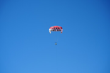 Benidorm, Spain – September 8 2025: Parasailing adventure over Levante Beach with a clear blue sky view.