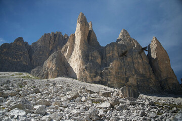 Majestic rocky spires of the Dolomites rising into clear blue sky with birds, iconic alpine mountain landscape of northern Italy
