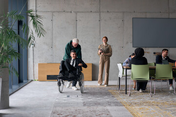A diverse team of business colleagues, including a director in a wheelchair, engages in a...
