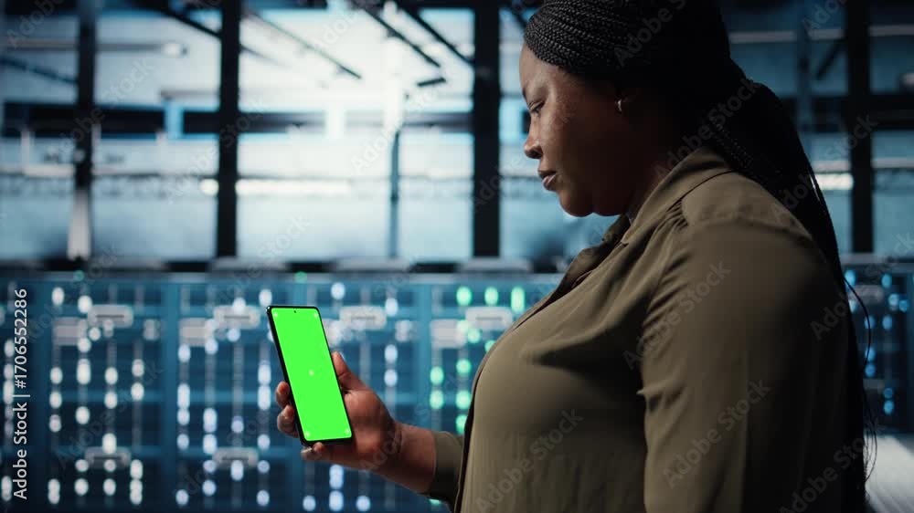Poster manager using app on chroma key phone to check server farm energy consumption. data center system ad
