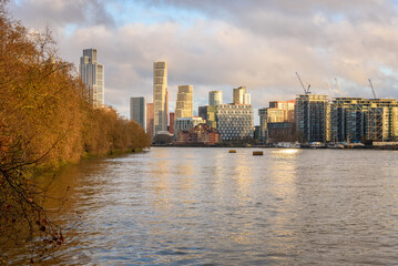 Naklejka premium New high rise apartments on the bank of river Thames in London at sunset in in early December