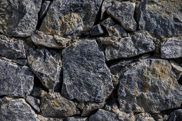 Rough natural stone wall surface as architectural background