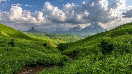 Obraz premium A stunning landscape featuring lush green hills rolling beneath a dramatic sky filled with clouds and distant mountains, perfect for nature-themed projects, travel promotions, or relaxation imagery,