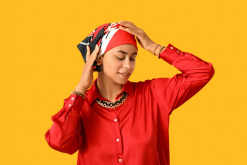 Beautiful African-American woman in headscarf on yellow background. Kwanzaa celebration