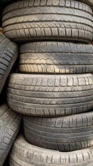 Stacked used tires, dirty, worn treads