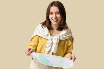Female traveler with map on beige background. Itinerary concept
