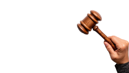 A wooden gavel held in a hand against a black background