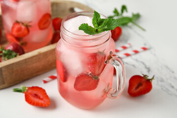 Glass of tasty cold cocktail with strawberry on marble background, closeup