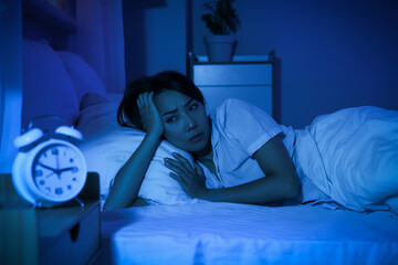 Young Asian woman suffering from insomnia in bed at night