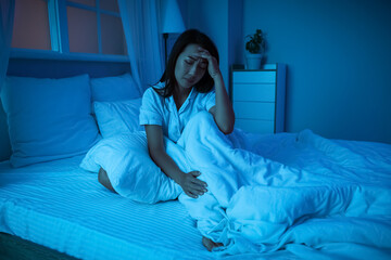 Obraz premium Young Asian woman suffering from insomnia in bedroom at night