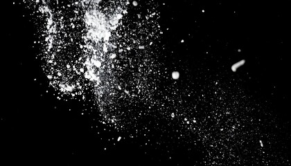 A monochrome image of a white powder scattering across a black background, creating a sense of motion