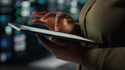 Close up of technician working in data center using tablet to optimize network infrastructure. IT expert in server farm diagnosing and resolving hardware malfunctions using device - Powered by Adobe