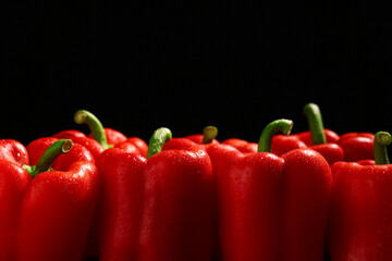 Red bell peppers on black background