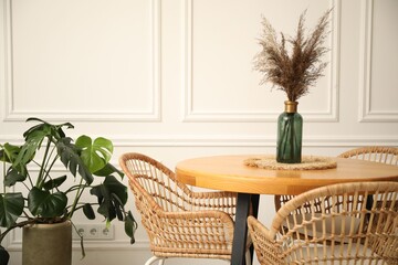 Wooden table with decor and stylish chairs in dining room