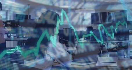 Typing woman wearing white blouse working on laptop at open-plan office, with stock chart overlays